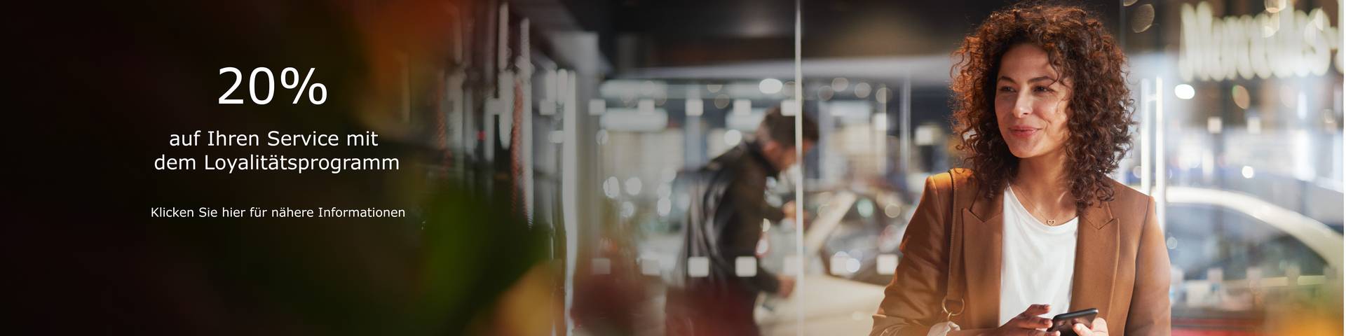 Eine Frau wartet auf ihren Mercedes-Benz und lächelt.